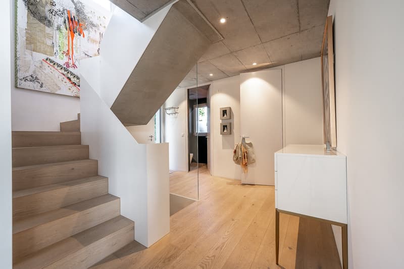 wooden stairs, white walls, wooden floor, glass wall, white cabinet, artwork