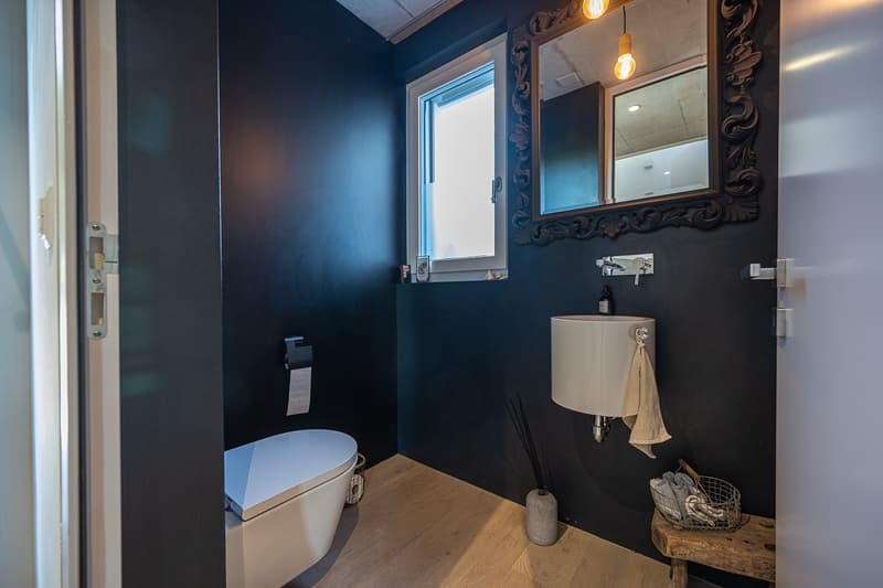 small bathroom with toilet, sink, mirror, and window
