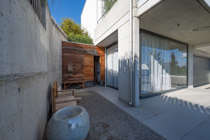 modern house, concrete wall, wooden bench, large glass windows, concrete floor