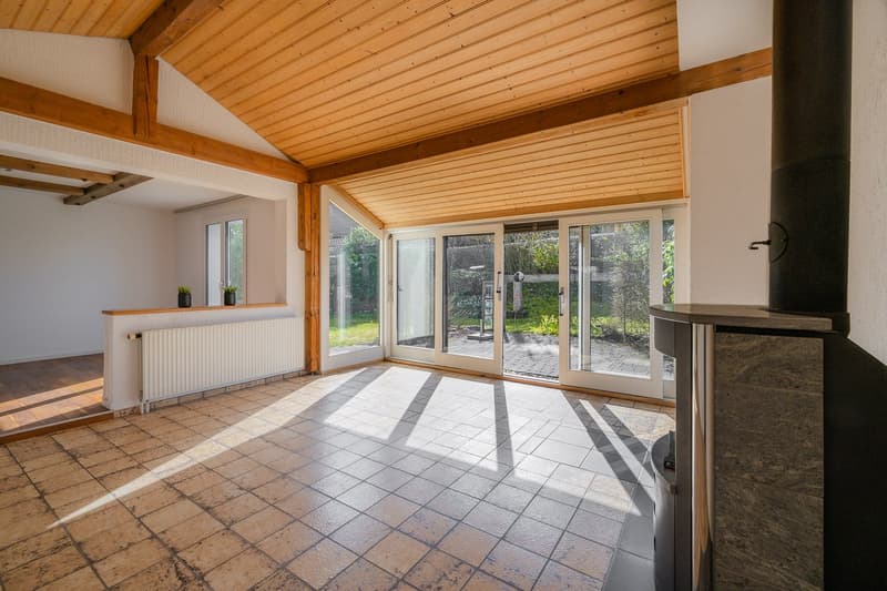 Wohnzimmer mit Specksteinofen mit Blick in den Garten