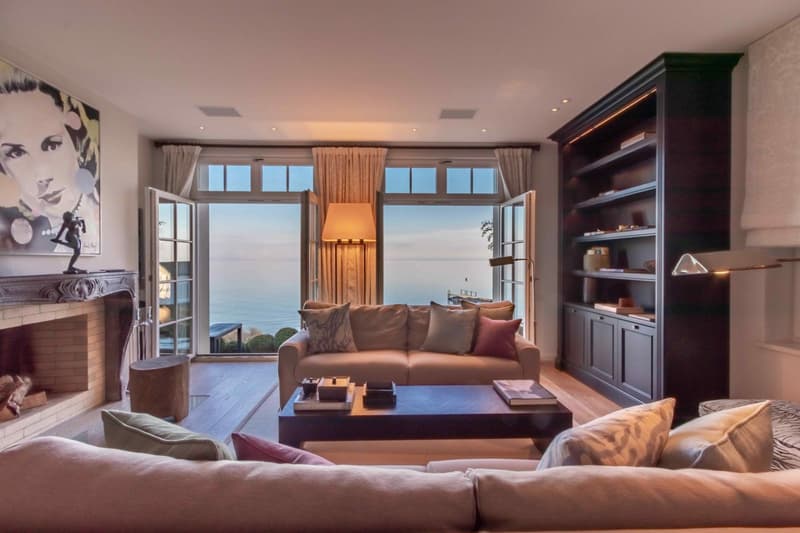 Ein grosszügiges Wohnzimmer mit gemütlichem Kamin und einzigartigem Panoramablick auf den Bodensee lädt zum Verweilen ein.