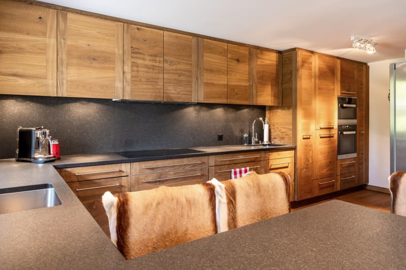 Moderne und hochwertige Küchenausstattung mit alpinem Flair und Miele-Geräten.
