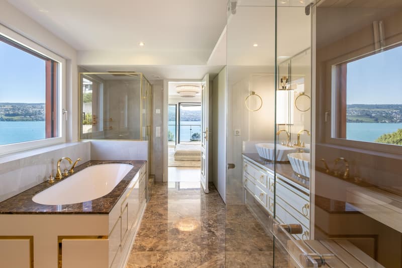 Luxuriöses Masterbad mit Seesicht, ausgestattet mit Sauna, Regendusche, Badewanne und elegantem Doppellavabo.