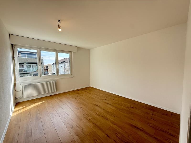 empty room, wooden floor, white walls, large window, radiator