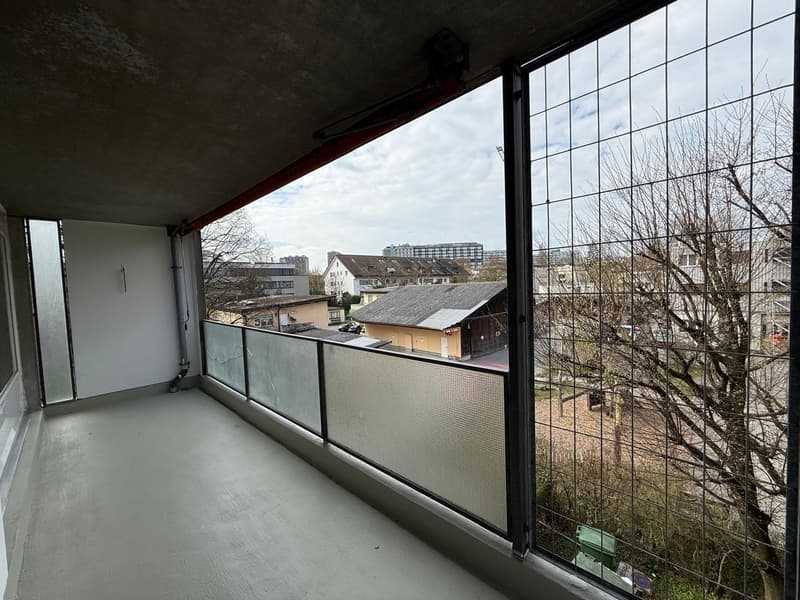 empty balcony with glass railings, concrete floor, view of the city
