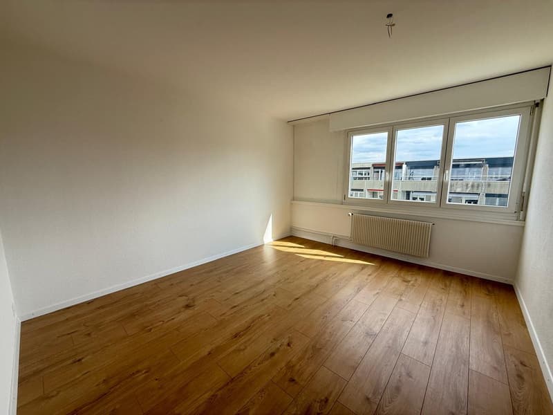 empty room, wooden floor, white walls, large window, radiator