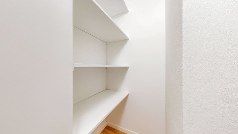empty room with white shelves and wooden floor