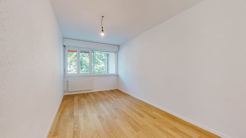 empty room, wooden floor, white walls, large window, white radiator