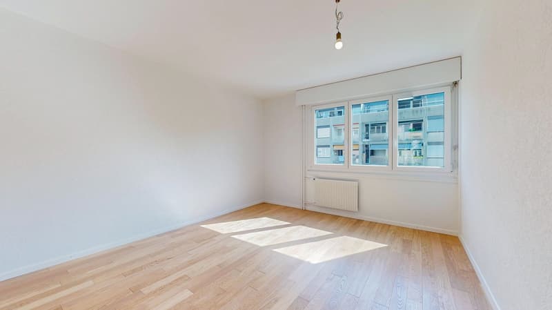 empty room, white walls, wooden floor, large window, white radiator