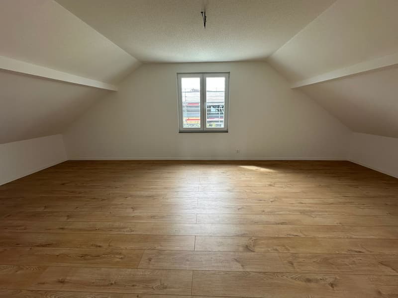 empty attic room, wooden floor, white walls, single window
