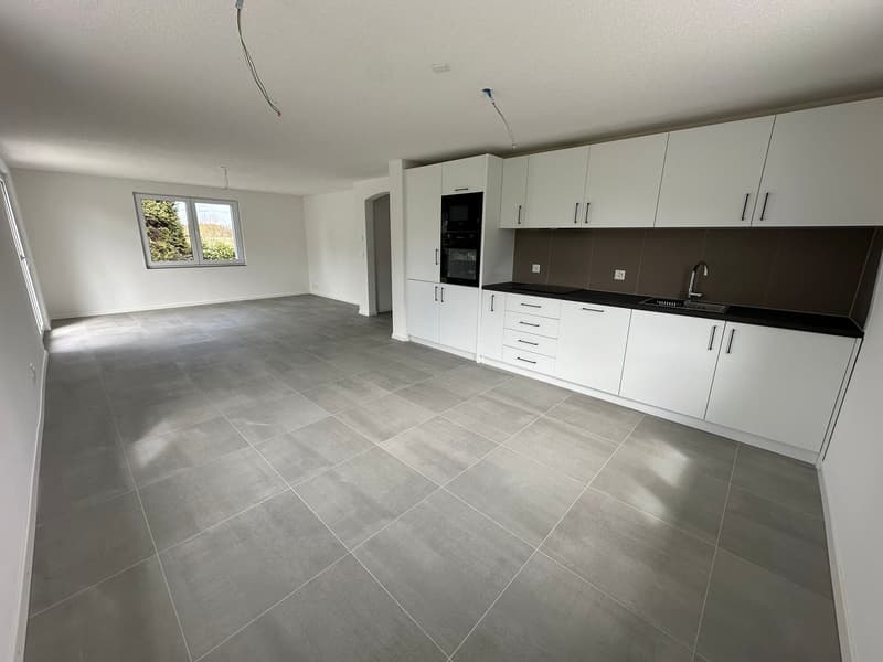 empty room, white walls, gray tiles, white cabinets, black countertop, sink, faucet, window