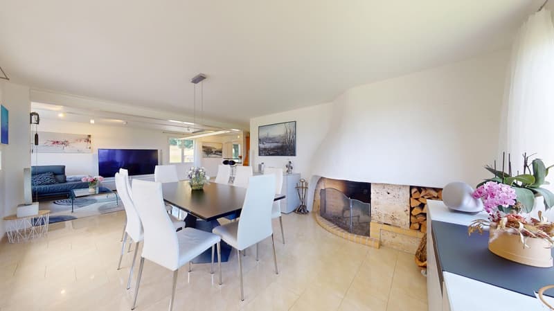 modern dining room with white chairs around a dining table, fireplace, flat screen TV, white tiled floor, white walls