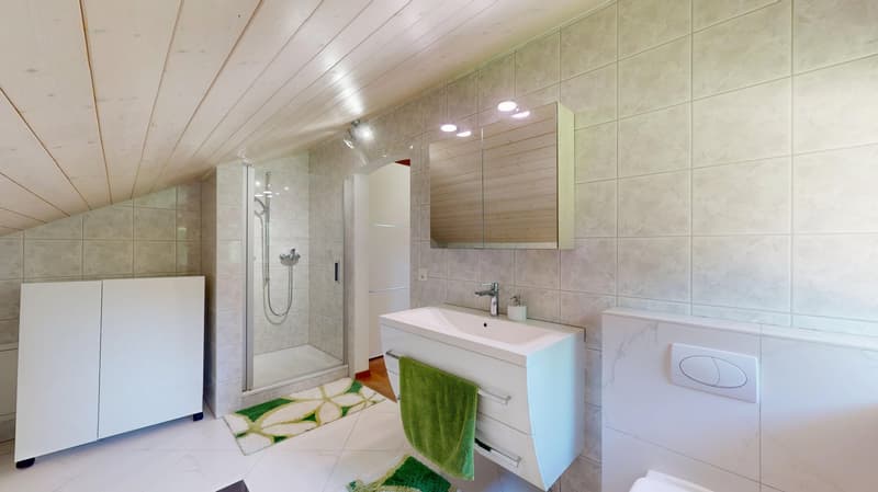 white tiles, wooden ceiling, shower with a glass door, white sink, wooden mirror, white toilet