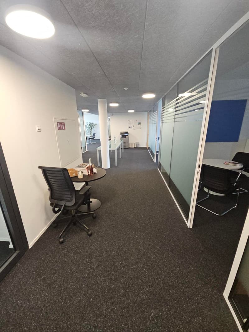 modern office interior, office desk, chair, round table, open area, light walls, dark flooring, glass walls