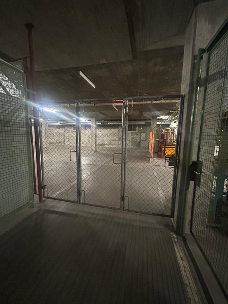 Parking lot with metal chain link fence, steel gates, large open area