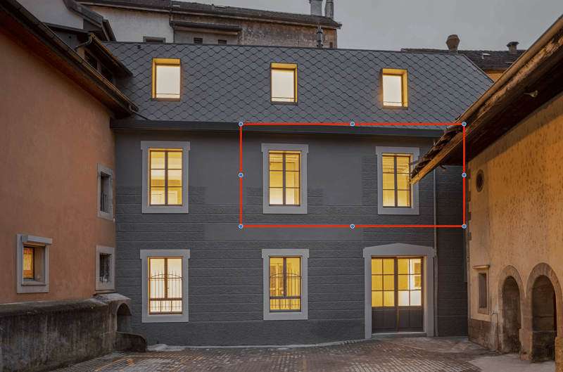 Three-story house with a gray exterior, multiple windows, and a large central window.