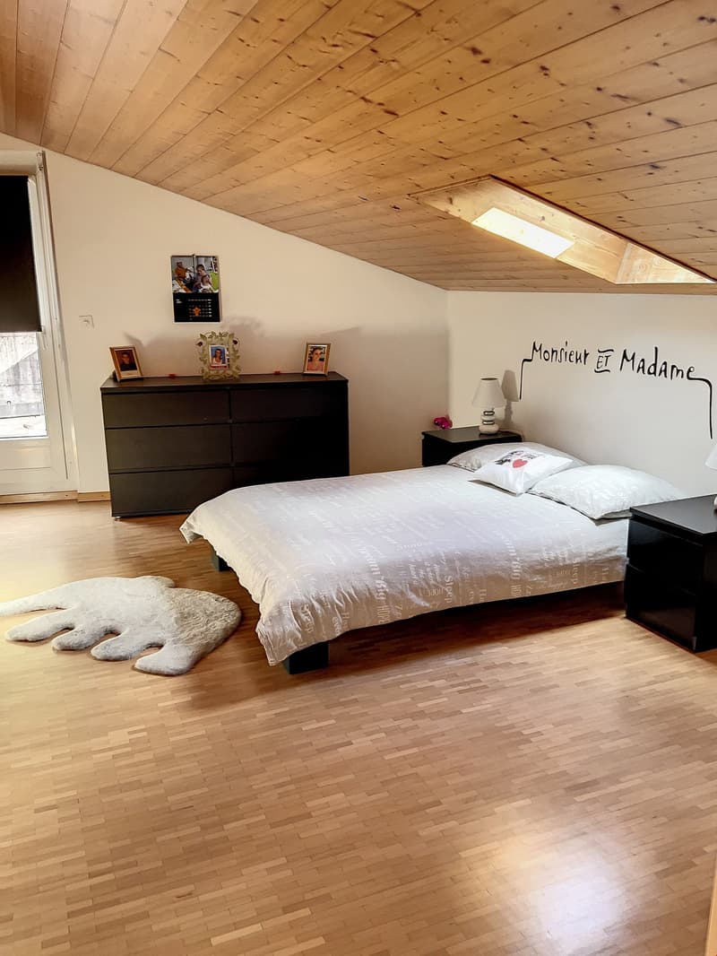 Master bedroom, bed with white bedding, two nightstands, lamps, fluffy rug, wooden floor, dark dresser with multiple drawers, picture frames on top, mural on the wall