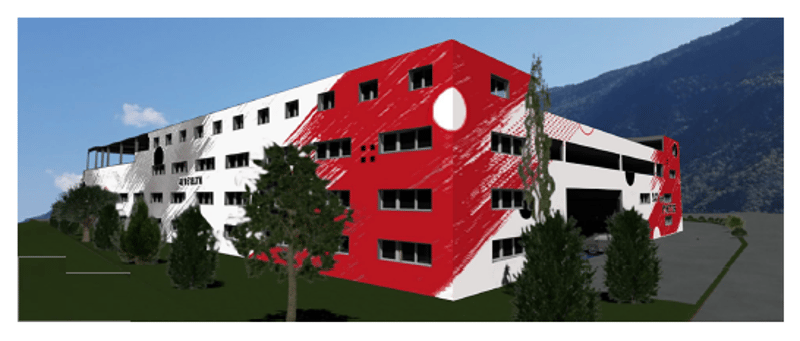Three story building, red and white paint, many windows, entrance garage, trees, grassy area, mountains in background