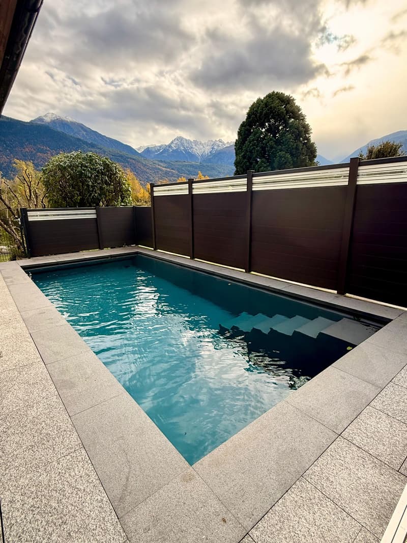 rectangular pool with steps, tiled around, wood fence, scenic view