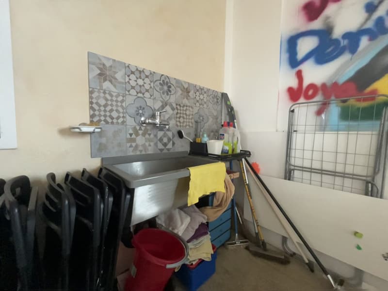 small sink, faucet, cleaning utensils, blue storage box, red bucket, chairs