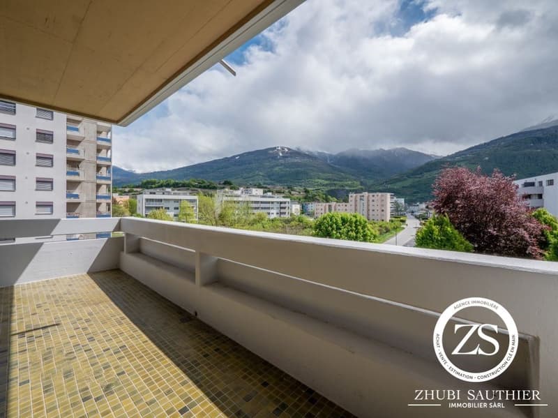 balcony with tiled floor, white railing, view of the city