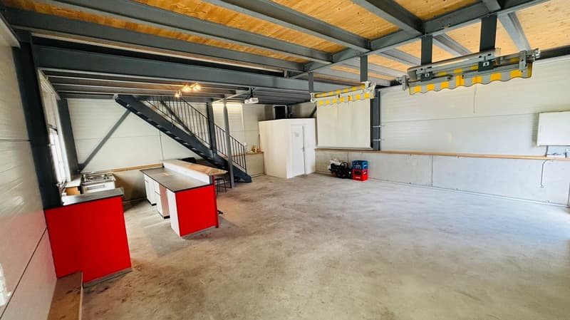 empty interior, concrete floor, metal ceiling, wooden stair, counters, open door, ceiling lamps, projector, white walls, large window