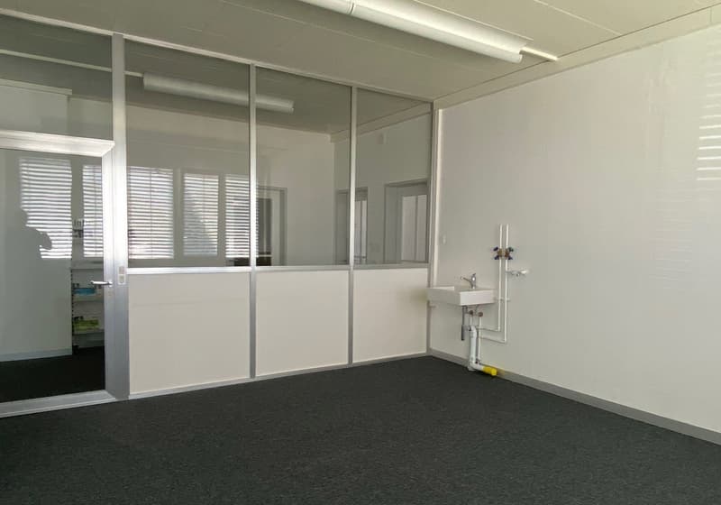 Empty room, glass walls, sink, pipes on the wall