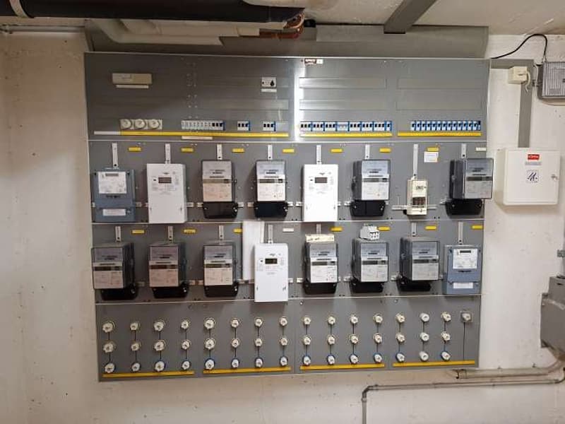 Meter box with multiple meters, switches, and indicator lights installed on a wall