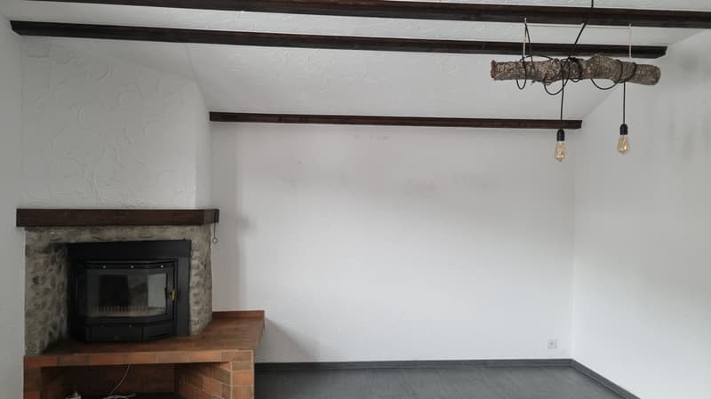 empty room, fireplace with stone wall, gray floors, wooden ceiling