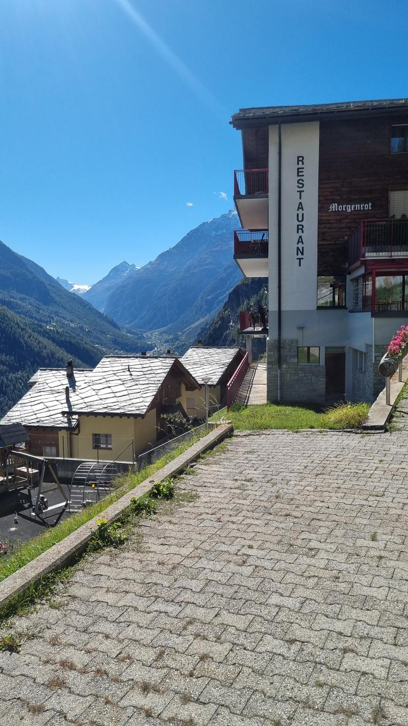 two story house, balconies, mountains in the background