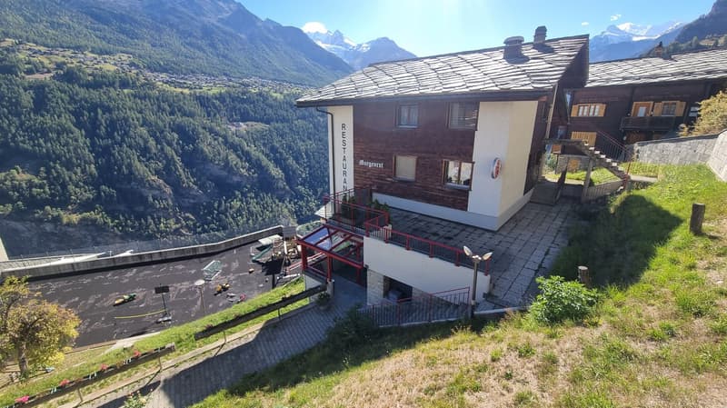 Mountain house, wooden exterior, elevated location, stairs, multiple windows, nearby playground