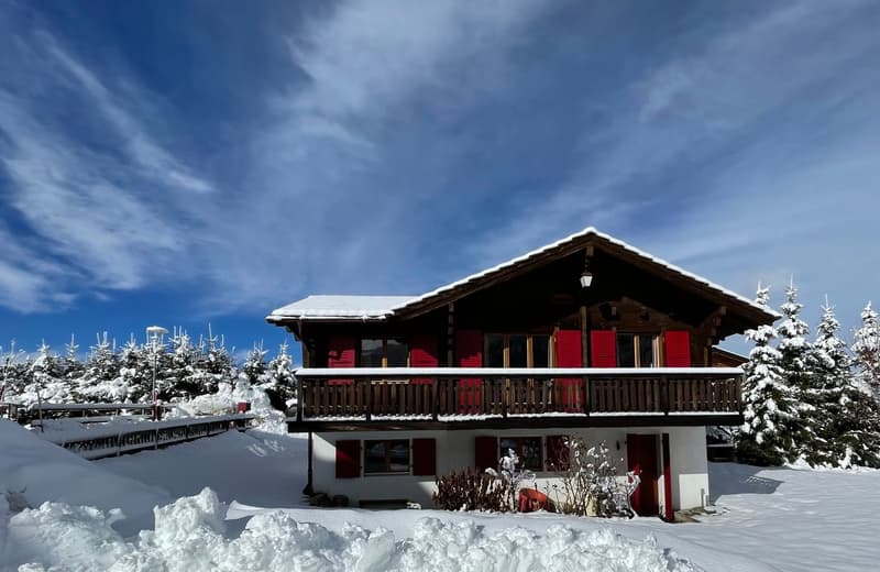 2 story, wooden architecture, red shutters, wooden balcony, white walls, snowy surroundings