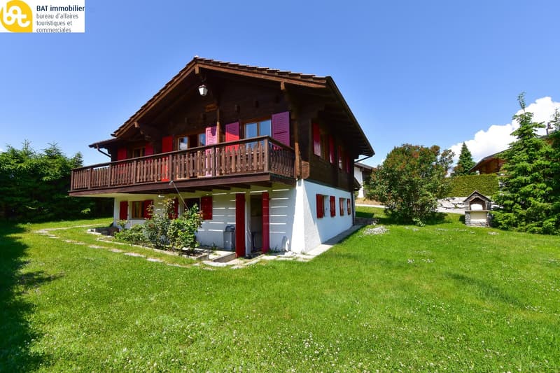 2-story wooden chalet, red shutters, balcony, white walls, sloping roof, garden