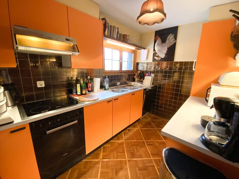 modern kitchen, orange cabinets, black appliances, tiled floor, sink, stove
