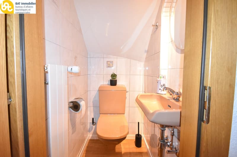 Tiled bathroom with toilet, sink, and washing machine
