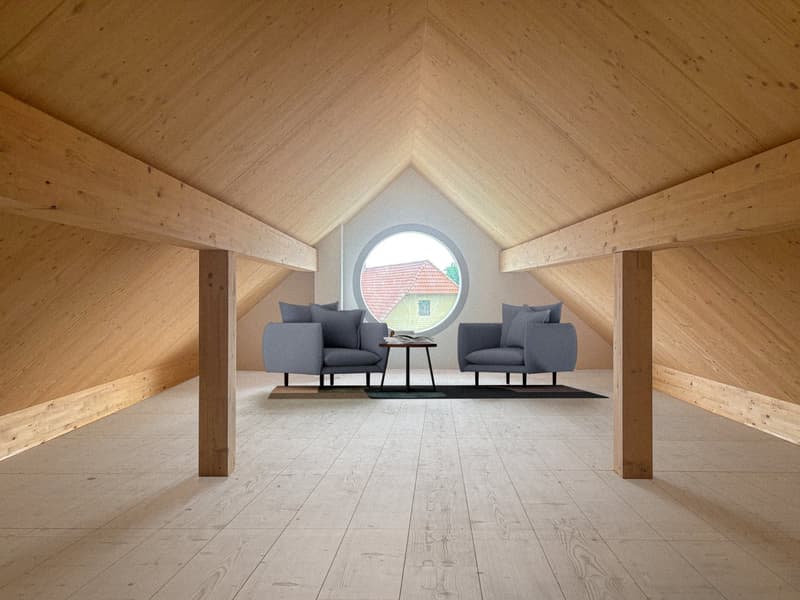 Spacious attic living room with wooden ceiling and walls, large round window, grey armchairs, and a small coffee table
