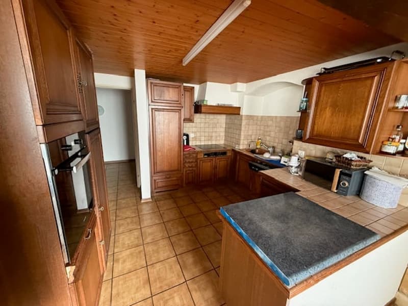 modern kitchen with wooden cabinets, ceramic tile flooring, integrated appliances