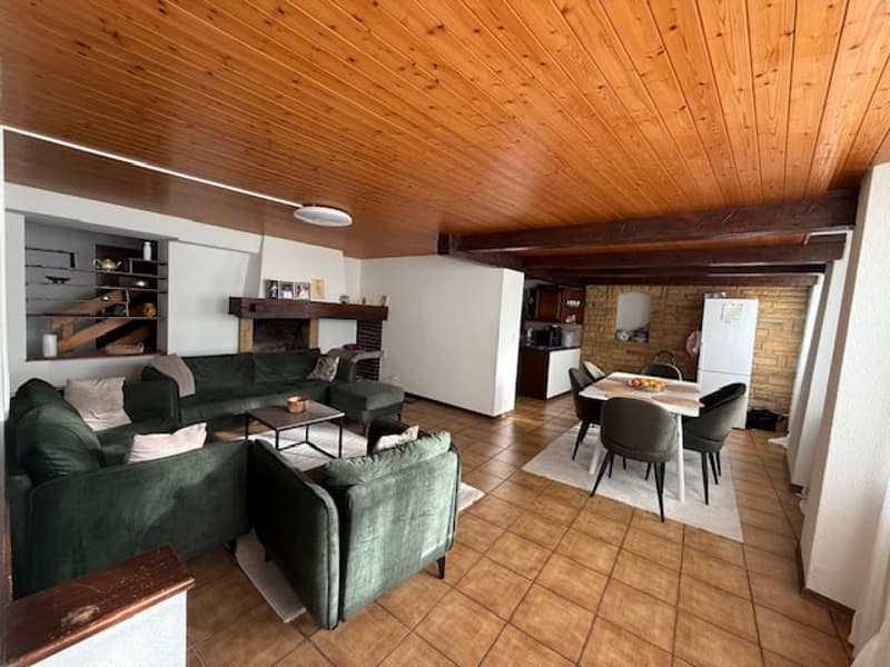 living room, green couches, wooden ceiling, fireplace, dining table, chairs, kitchen, refrigerator
