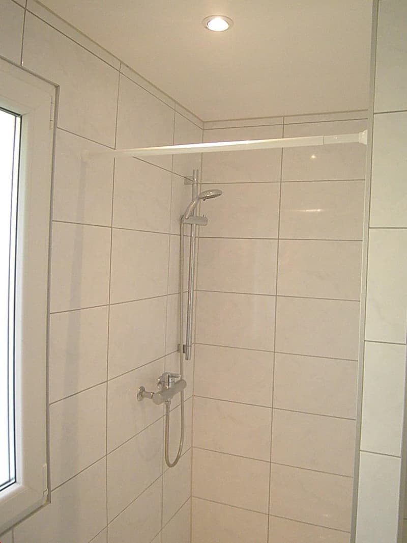 shower area with shower head, shower rail, and faucet