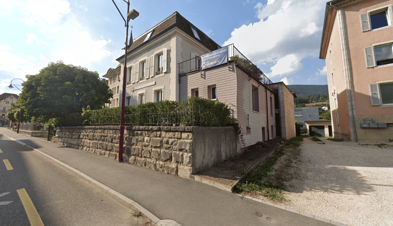 2 story building, stone wall, brick facade, terrace, metal fence, road, sidewalk