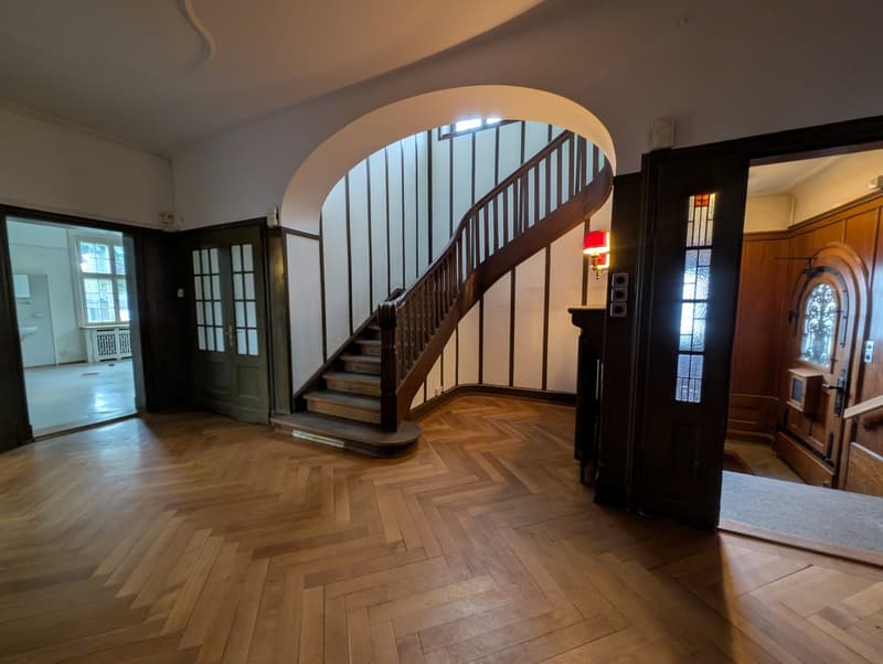 Wooden herringbone floor, spiral staircase, wooden doors, window, hallway