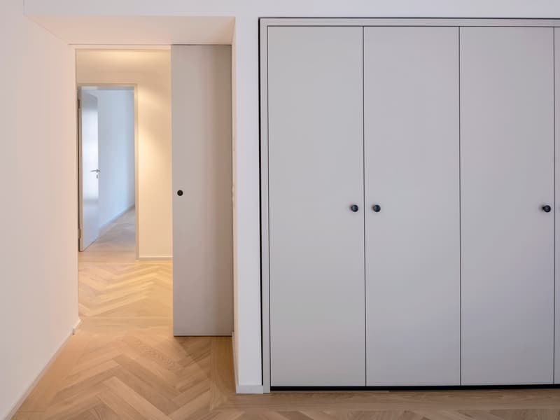 white walls, white door, wooden floor, closets