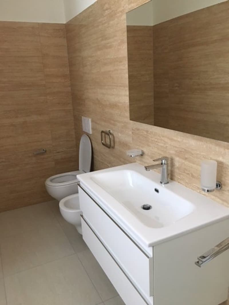 modern bathroom, white walls, white floor, white toilet, white sink, white cabinet, faucet, mirror, candle holder