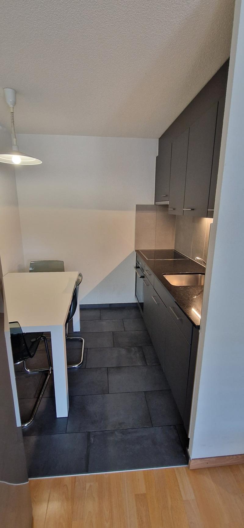 white table, black chairs, open kitchen, tile flooring, kitchen appliances