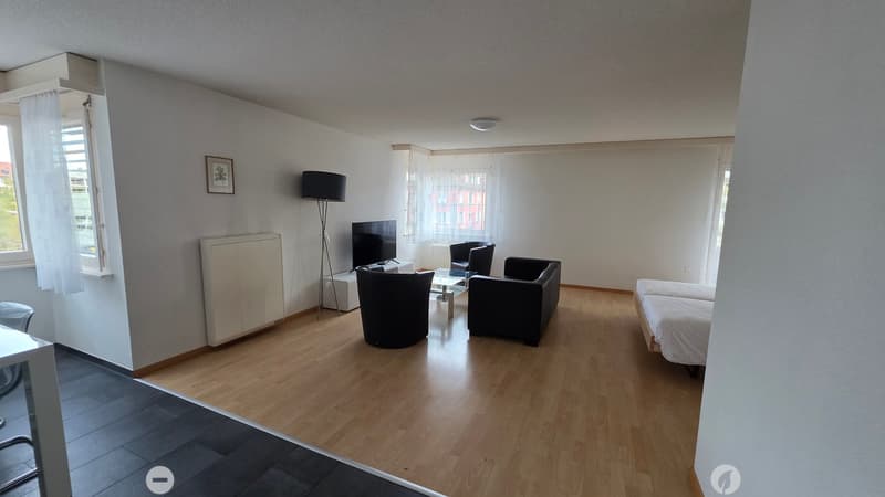 2 single beds, 2 black arm chairs, black lamp, tv stand, TV, glass table, white radiator, wall picture