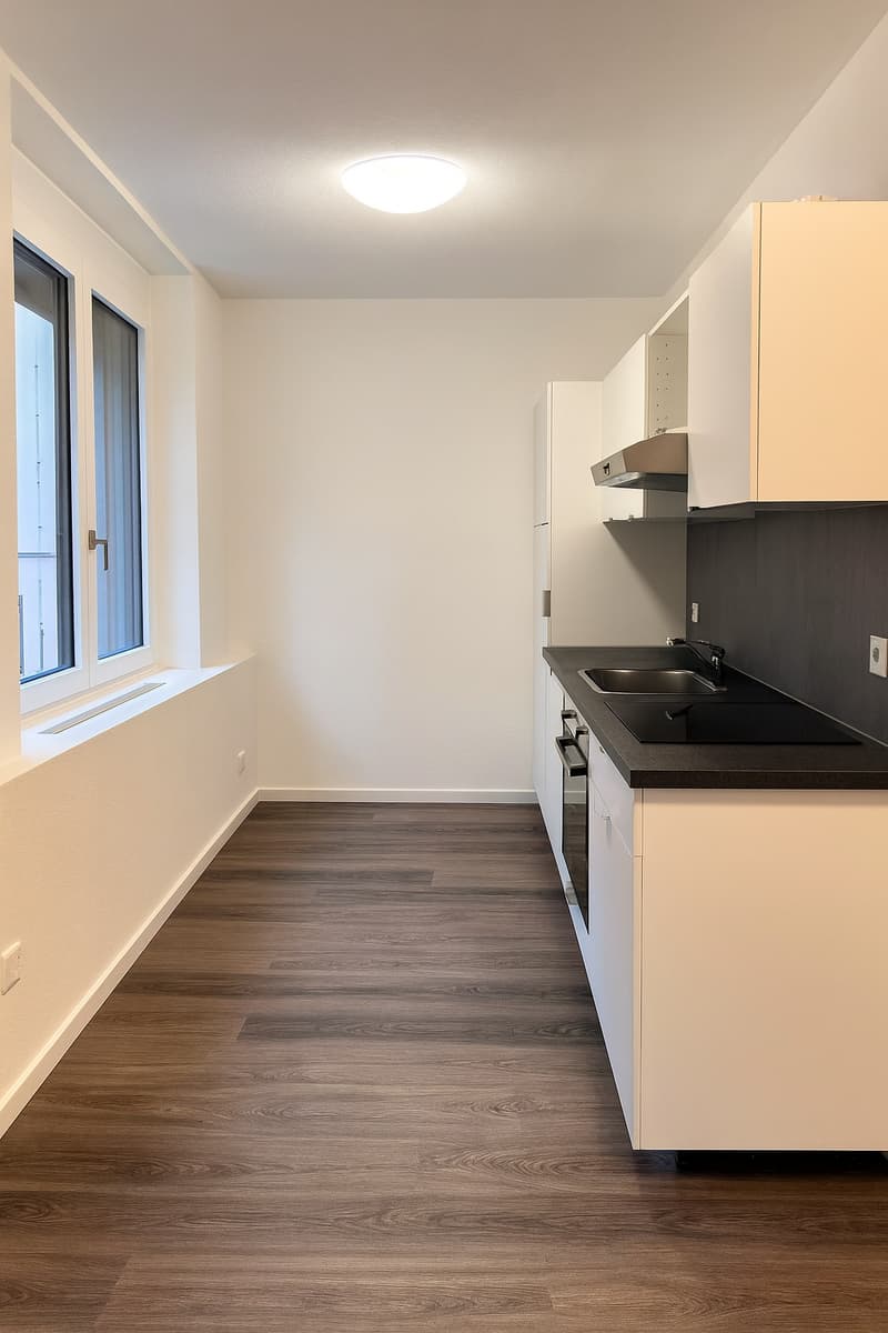 empty room with white walls, wooden floor, kitchen with double sink, stove, and oven, kitchen island with built-in hood extractor