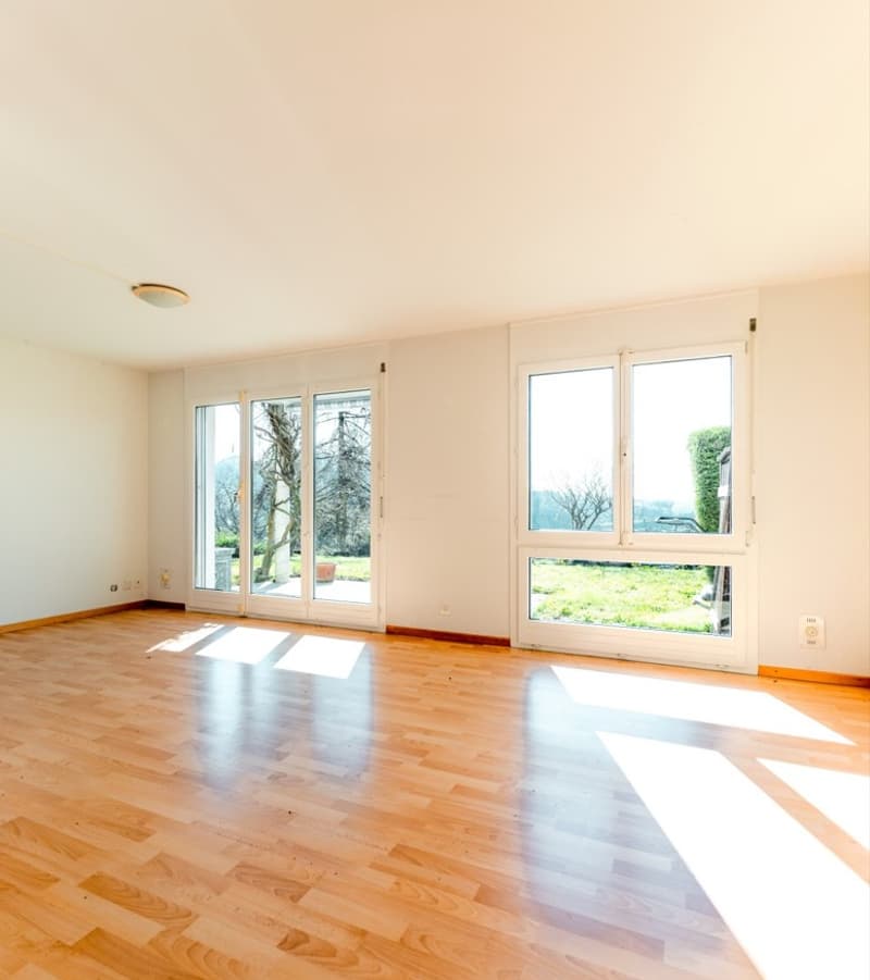 empty room, hardwood floors, large windows, sliding doors leading to a balcony