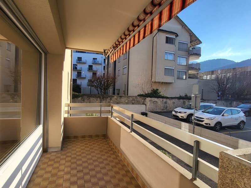 wooden floor, tiled floor, large window, metal railing, small wall with potted plants, mountain view