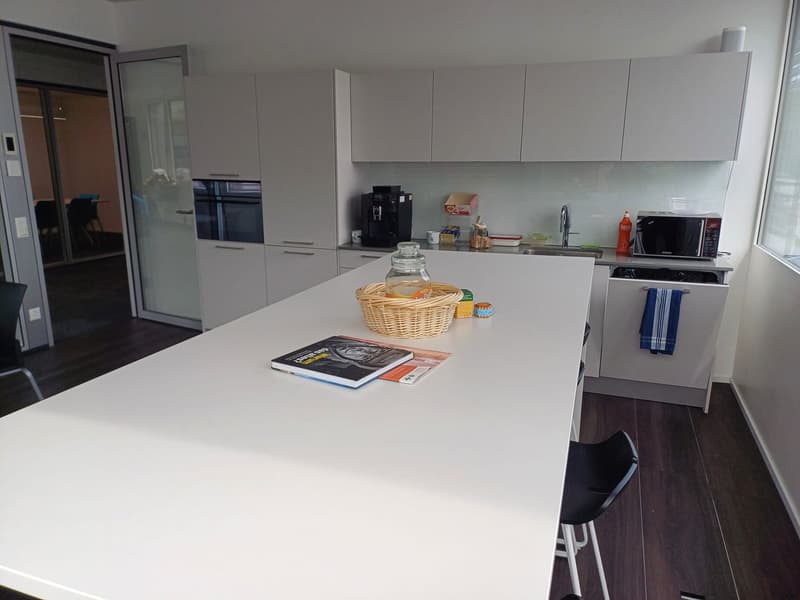 Modern kitchen with white cabinets, white countertop, stainless steel appliances including a dishwasher, and a wicker basket on the counter.