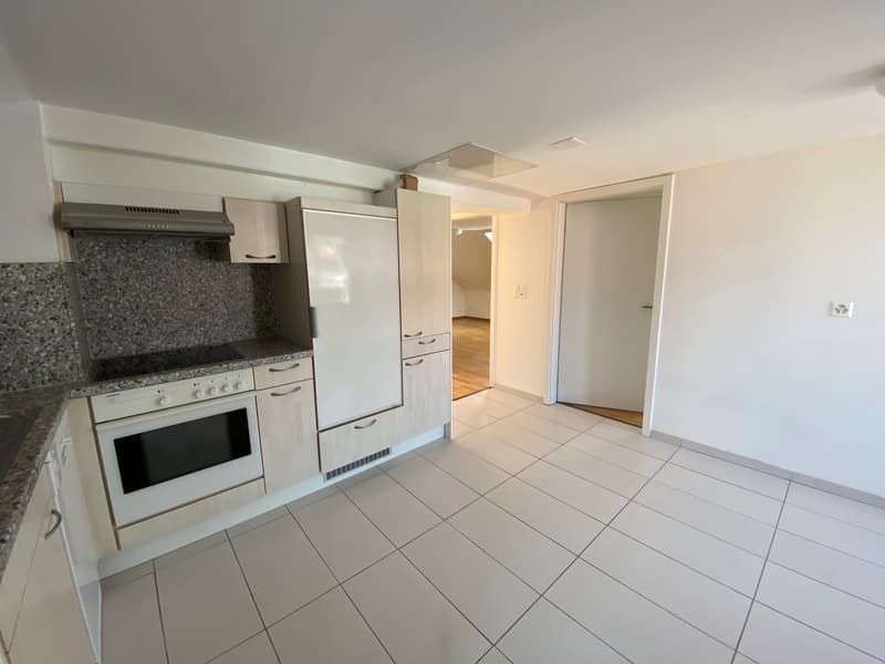 modern kitchen with white tiles, white cabinets, white appliances, granite countertop, and a wooden floor